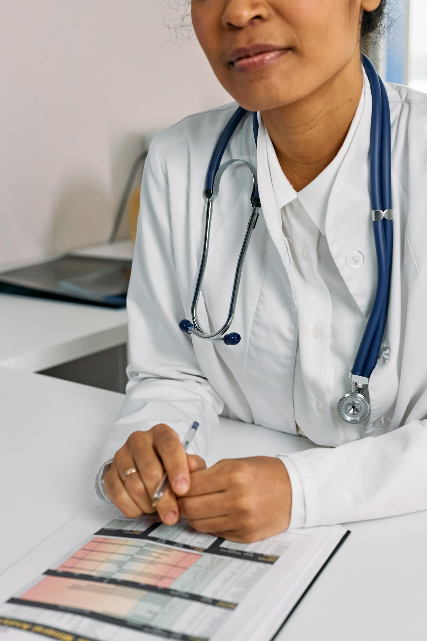 Professional African American female doctor reviewing documents in a clinical setting.